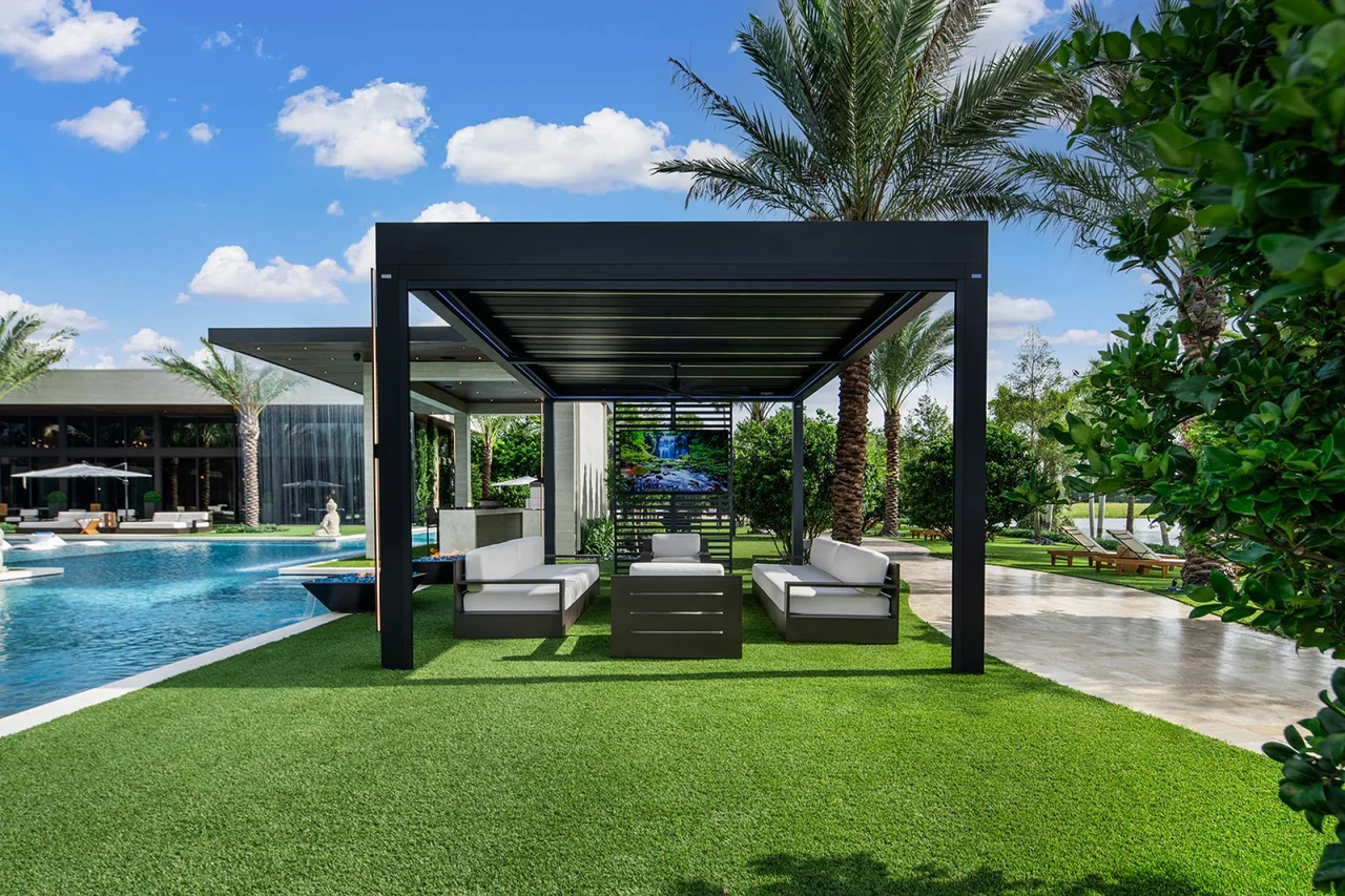 Pergola with a slatted side panel and integrated lighting beside the Casa Maranello pool