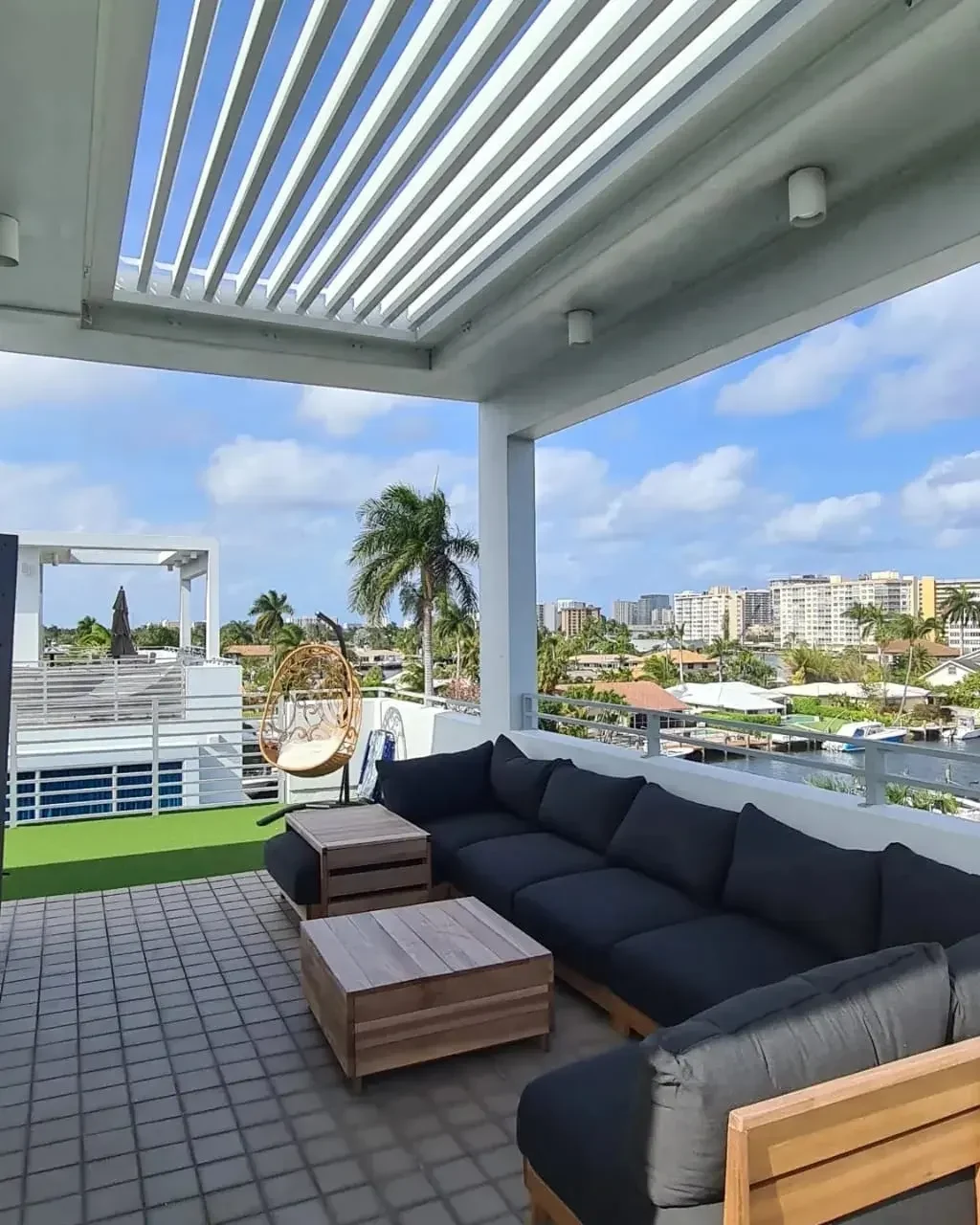 White louvered pergola above a furnished elevated terrace in Pompano Beach